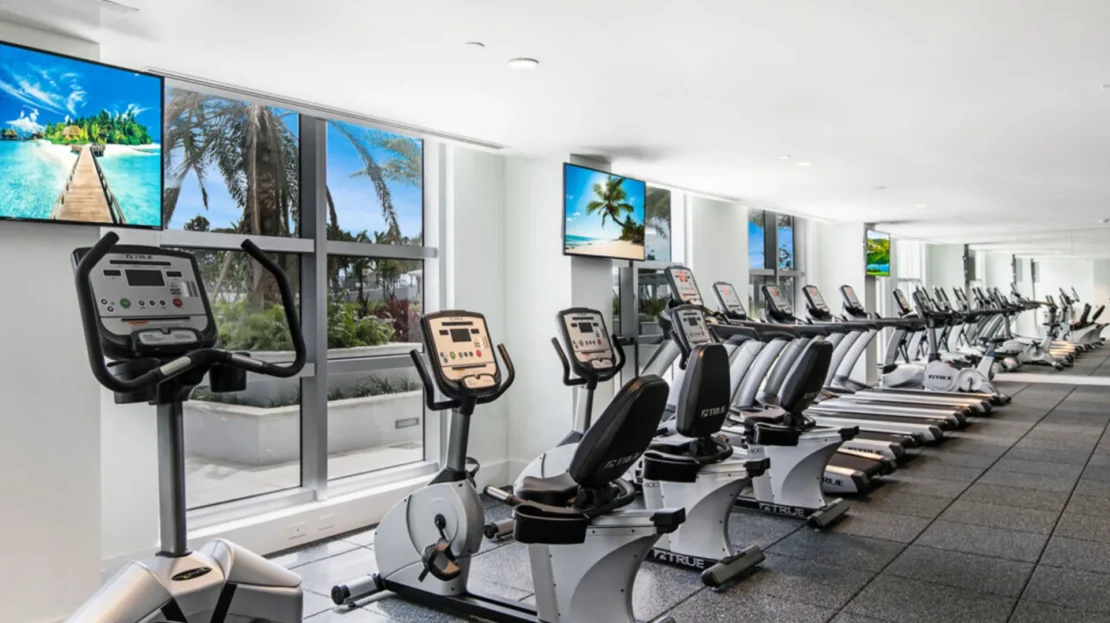 Gimnasio especializado en cardio con televisores y ventanales