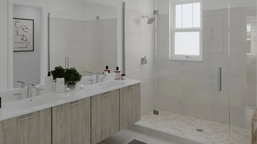 Baño moderno con dos lavamanos y puerta de vidrio