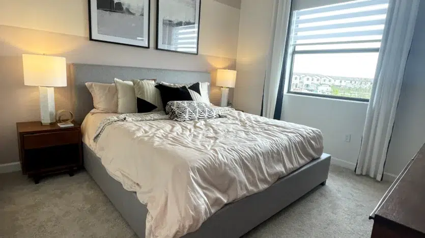 Dormitorio de una cama con cuadros y ventana