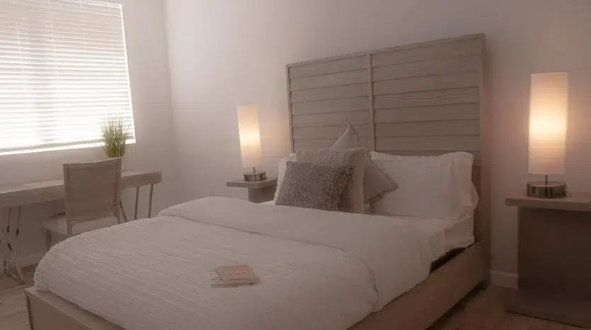 Dormitorio de una cama con lámparas y persianas