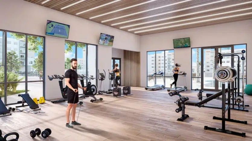 Gimnasio moderno con múltiples máquinas y televisores con entretenimiento